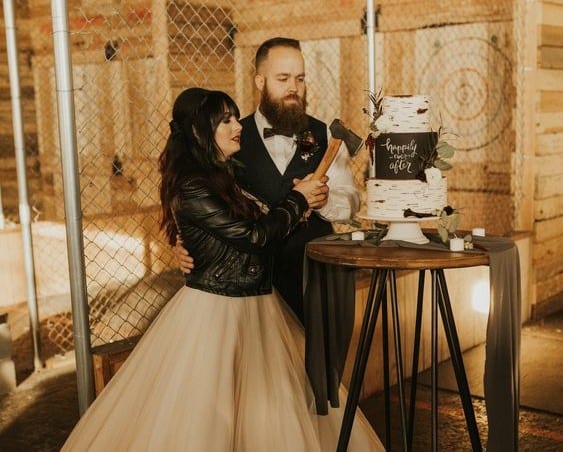 Pittsfield bride and groom cutting axe throwing wedding cake